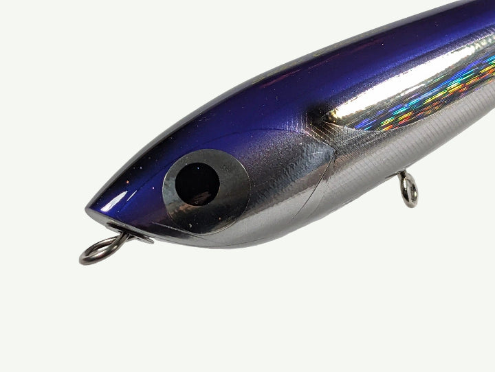 Close-up of a metallic blue fishing lure on a light gray background