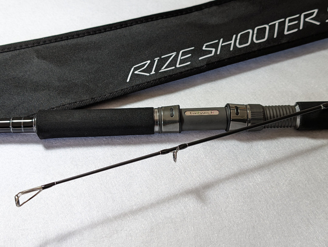 Tailwalk RIZE SHOOTER SSD S910H Shore Jigging Rod with a black butt and silver tips, displayed next to its black carrying case with the brand 'RIZE SHOOTER' printed on it.