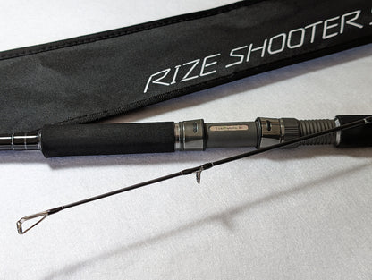 Tailwalk RIZE SHOOTER SSD S910H Shore Jigging Rod with a black butt and silver tips, displayed next to its black carrying case with the brand 'RIZE SHOOTER' printed on it.